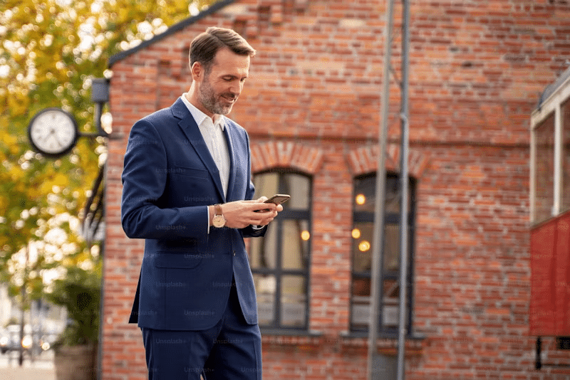 a man on his phone in a blue suit