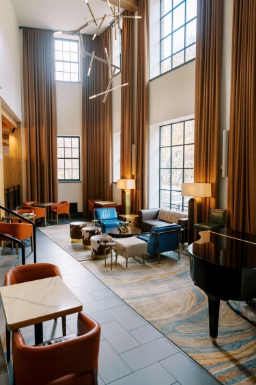 Lobby with a grand piano and sitting areas around it